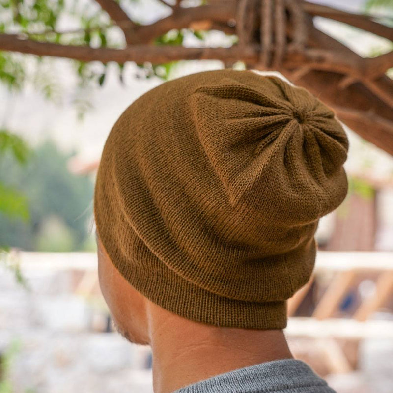 Man wearing brown colored baby alpaca wool beanie. view from the back