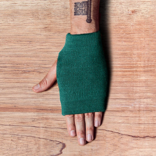 Hand with inside out gloves made of alpaca wool in the color emerald