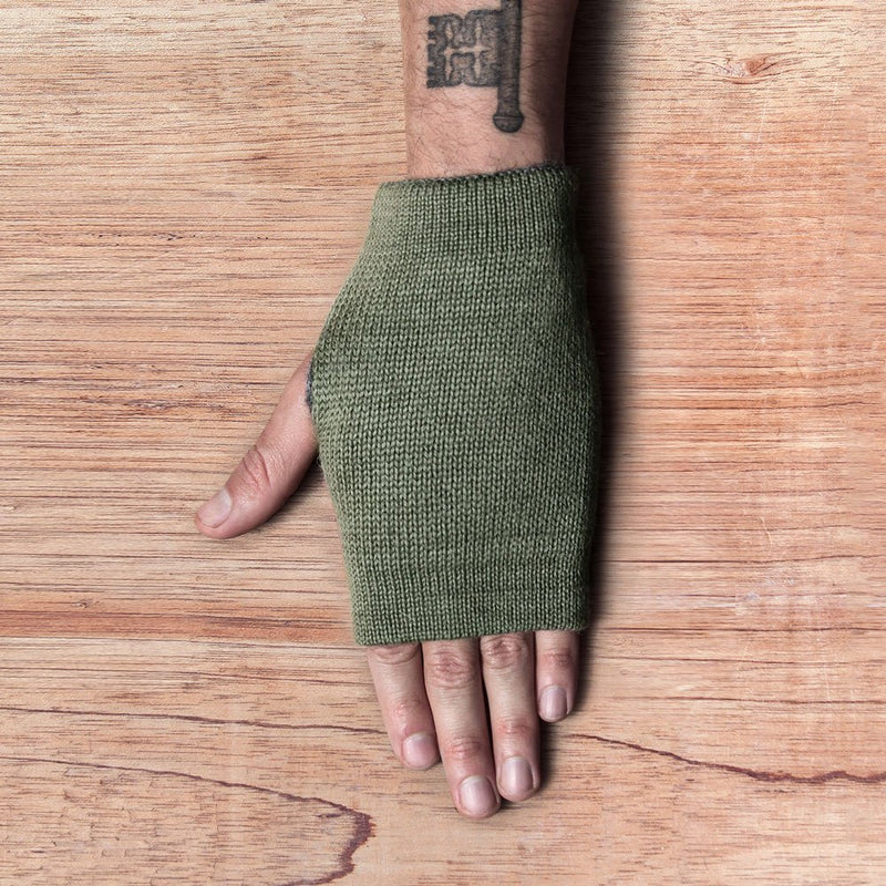 Hand with inside out gloves made of alpaca wool in the color green