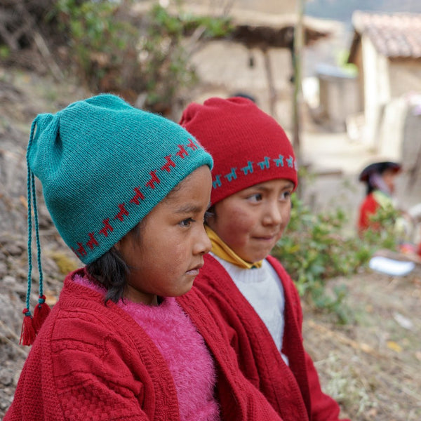 Girls wearing baby alpaca 2 in 1 hat and loop color red and blue